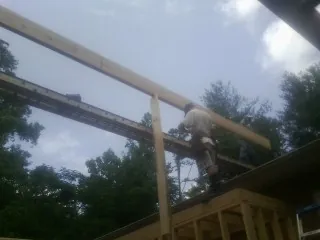 Carpenter setting a ridge beam over a new addition frame — Ice Dam Removal by Roofing Brothers in Kendallville