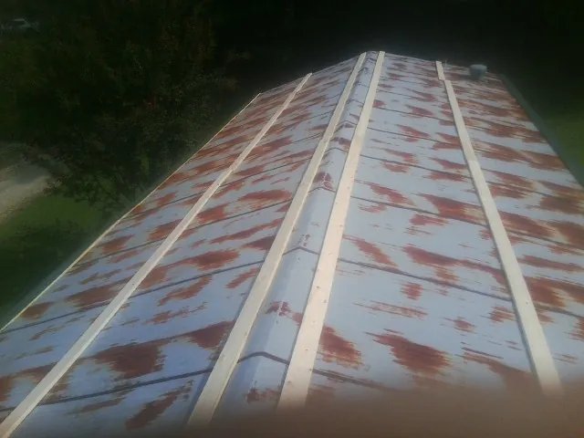 Rusted metal roof panels with new wood purlins before replacement — Storm Damage Roof Repair in Kendallville by Roofing Brothers