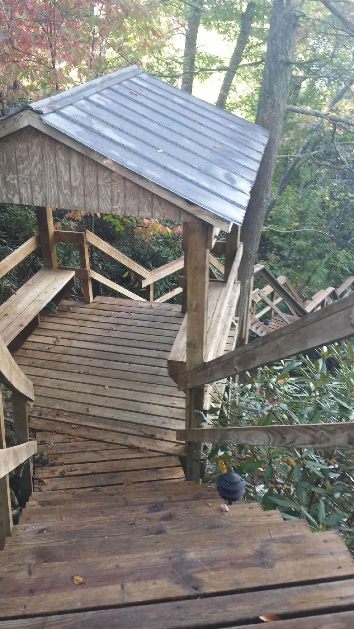 Metal roofed shelter over wooden steps on a wooded walkway — Skylight Repair & Installation work by our crew in Kendallville