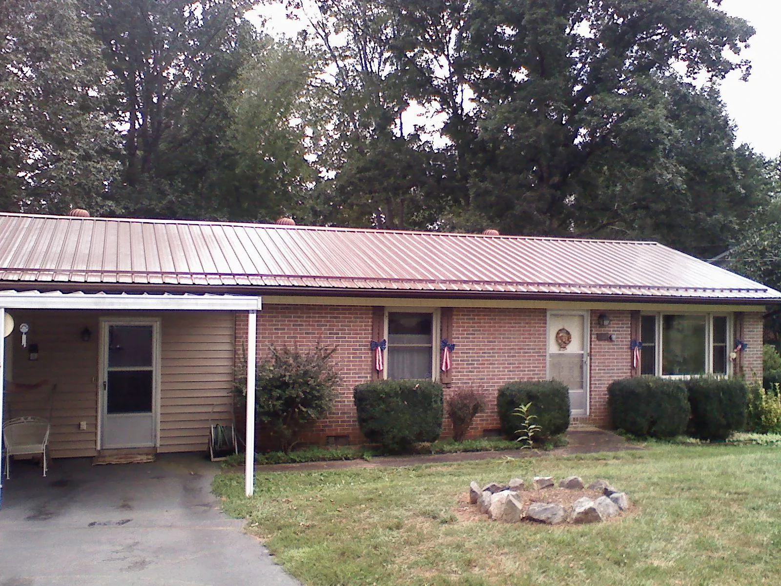 Bronze metal roof and carport on a brick ranch home — Roof Repair work by our crew in Kendallville